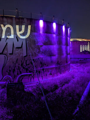 DMX controlled decorative lighting in purple around and on Reading containers in Tel Aviv, including projection of Hanukkah symbols such as menorahs and wishes for a "Happy Holiday"