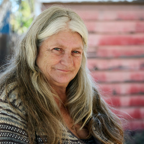 Trish Gaut sits outside Central Oregon Villages where she lives in Bend. After living in a fifth-wheel in La Pine for approximately five years, Gaut connected to resources through Thrive and moved into the Villages in August. She said being out of the elements and not having to constantly worry about a generator for heating have been huge reliefs. Photo by Joe Kline.