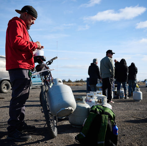 Ricky Saunders waits in line to exchange a propane container during a weekly service provider gathering near encampments off Antler Avenue in Redmond. Jericho Road runs the weekly propane exchange, as well as providing meals and distributing food. Photo by Joe Kline.