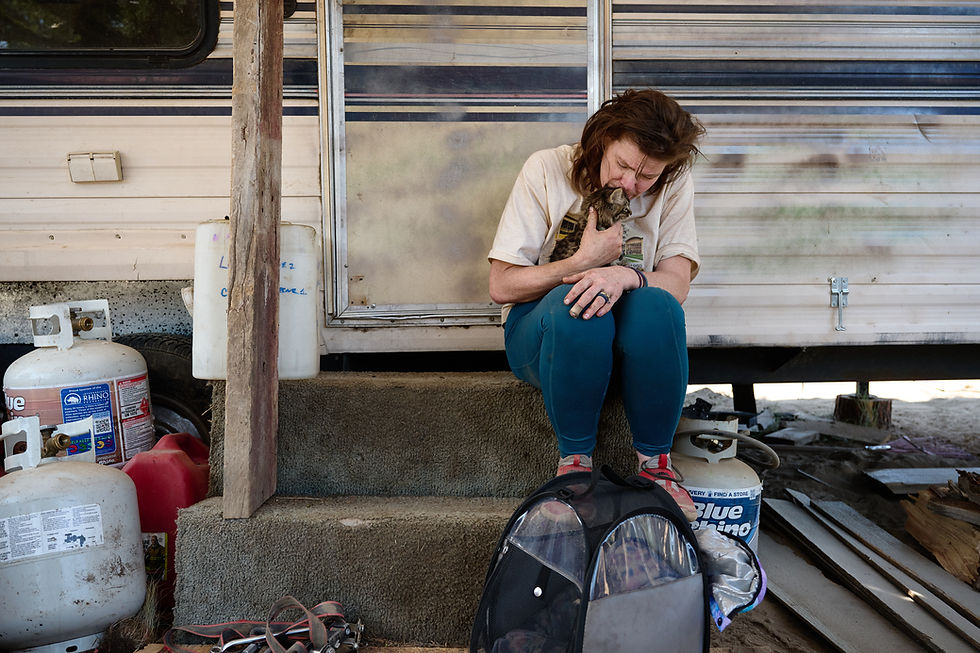 Christine Greene hugs her cat Zippy while sitting outside the camper where she and her partner live east of Bend. Photo by Joe Kline.