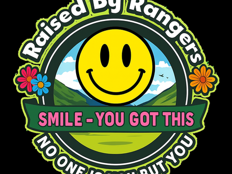 A bright circular Raised by Rangers emblem featuring a large yellow smiley face against green mountains and a blue sky. Pink flowers decorate the sides, and the text reads “SMILE – YOU GOT THIS” on a green banner, with “NO ONE IS YOU BUT YOU” along the bottom edge.