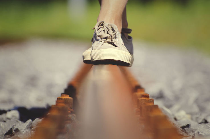 Pies caminando por una vía