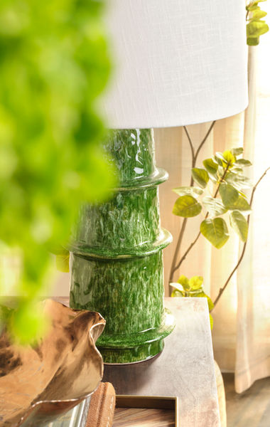 Green ceramic table lamp photographed in an interior setting