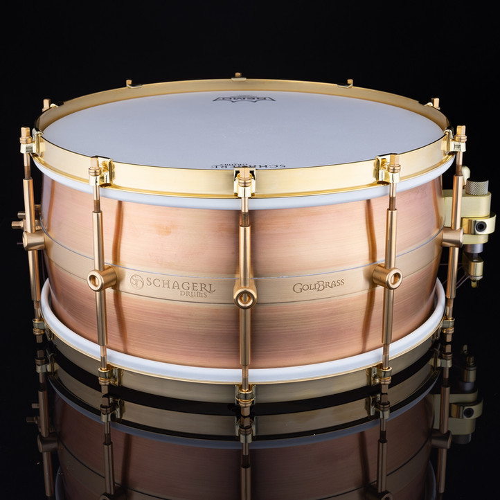 „Dimensioni: 14 "x 5" 14 "x 6,5" Fusto - Fusto curvo a 5 pezzi Schagerl Drums: 0,8 mm / ottone dorato (MS85) Filtro: Schagerl - TrickDrums Multistep modificato (oro) Fili rullante: Schagerl - filo per rullante personalizzato 14 str. SDB1414 Alette: Capicorda a tubo in ottone massiccio a contatto singolo Schagerl 10 pz. Cerchi: cerchi in ottone a flangia singola grezzi con artigli Finire: crudo* * Non esistono due tamburi grezzi uguali. :: Ogni fusto include una borsa in velluto con coulisse ::