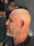 Homem careca de perfil com visual sempre alinhado assinatura