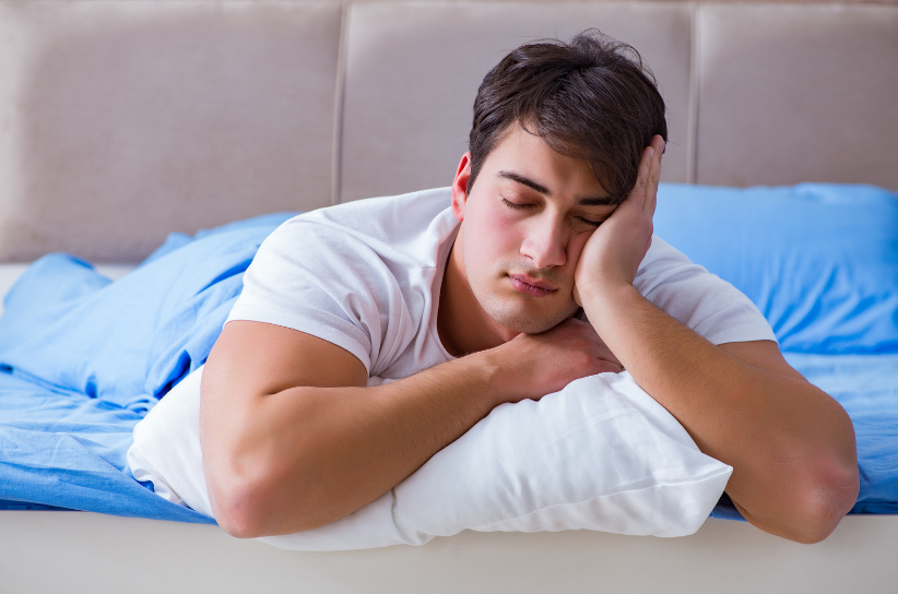 a man with insomnia issues sitting up in bed