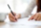 Hand of businesswoman writing on paper i
