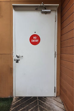 White security door with silver handle and lock and red "No Entry" sign