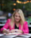 Jo Jenkins from Ladybird SEO writes in her pink notebook wearing a bright pink jacket and black top