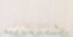 A lit up curtain with a well decorated table in front of it which is full of beautifu flowers