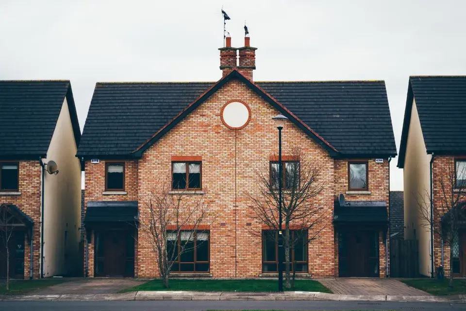 Pale brick new build semi-detached home with a dark grey roof 
