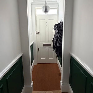 Modern white hallway with green wall panelling