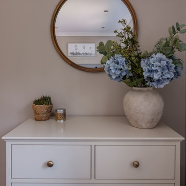 Full-home renovation to modernise family home with nature inspired interior design, guest bedroom with warm brown interior, antique brass handles, rustic pots, candles and flowers for styling