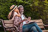 little adorable african american grandchild whispering to her smiling grandfather while si