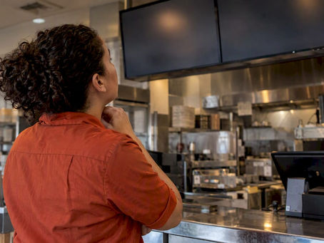 Manager checking a digital restaurant menu board