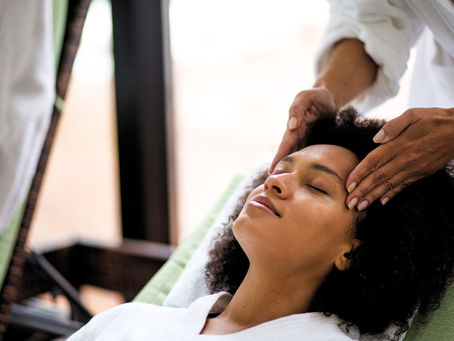 A black woman receiving a facial massage at the spa.
