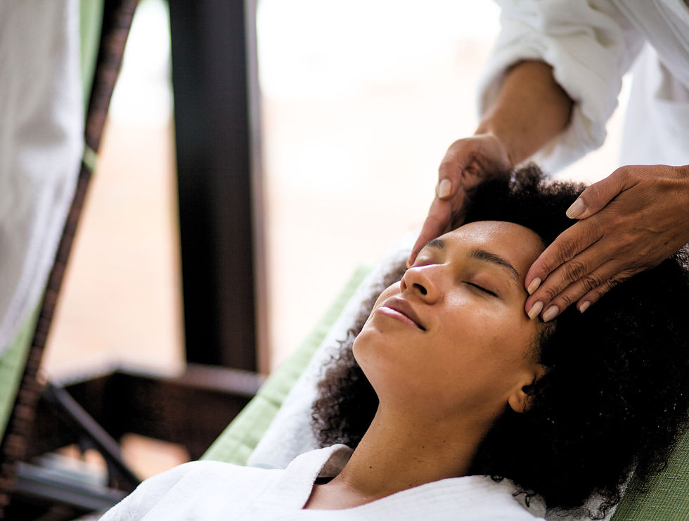A black woman receiving a facial massage at the spa.
