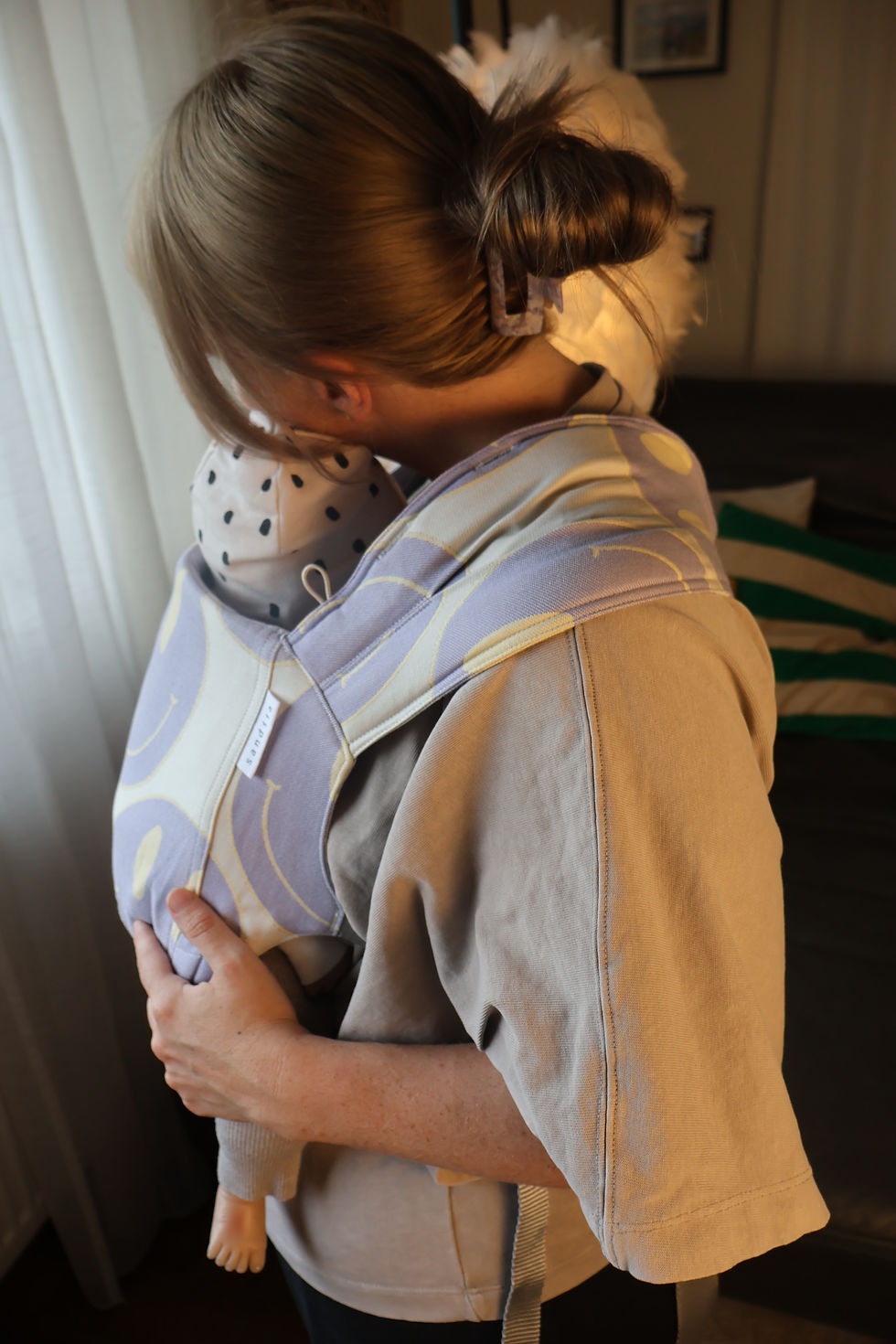 In einer Tragehilfe oder dem Tuch kannst du dein Baby nach einer Impfung schnell wieder beruhigen