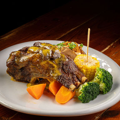 Charbroiled lamb rack glistening with spicy béarnaise. Served with a loaded baked potato, corn and seasonal vegetables at Jake's Charbroil Steaks.