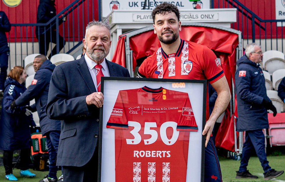 Roberts receiving a commemorative shirt to celebrate the milestone of 350 appearance for the club