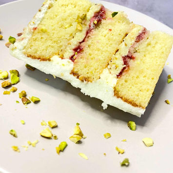 Fatia do bolo de pistache com geleia de framboesa