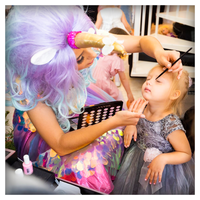 Beauty bar with full-face rhinestones, glitter makeup, sparkling hair, glitter tattoos, music, and a portable dressing table with kid-safe products.