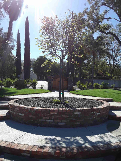 Outdoor fire pit by Mackintosh Drafting featuring modern stonework, integrated seating, and ambient lighting