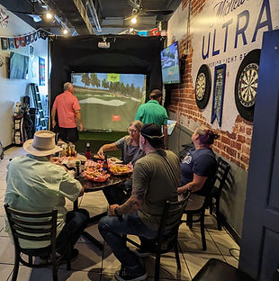Golfers watching a digital golf simulator