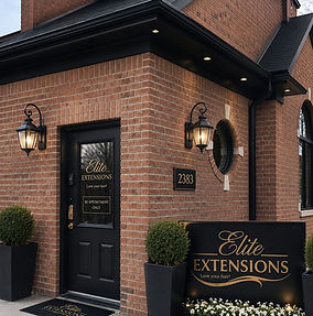 The brick exterior of the Elite Extensions Salon located in Highland, Michigan,