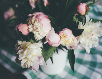 Blumenstrauß mit rosa und weißen Blüten auf einem grünen Tischtuch