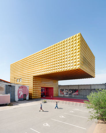 Exterior architectural perspective with angular golden facade