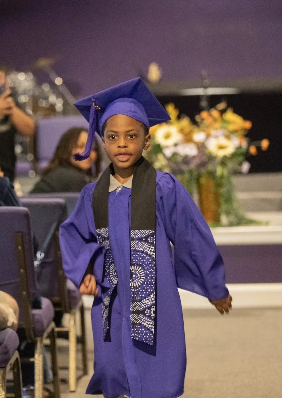 June 17, 2025, Minneapolis, MN – The first graduate of Morning Glory Montessori walks down the isle during his graduation.
