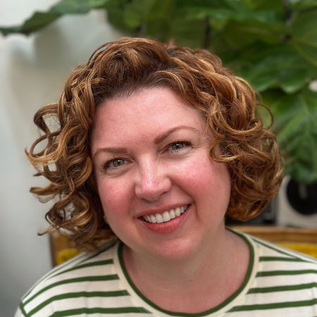 This is a curly haircut with hair past the shoulder, the hair color is red with blonde highlights.