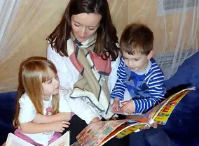 Maggie and Kitty & Owen looking at book.webp