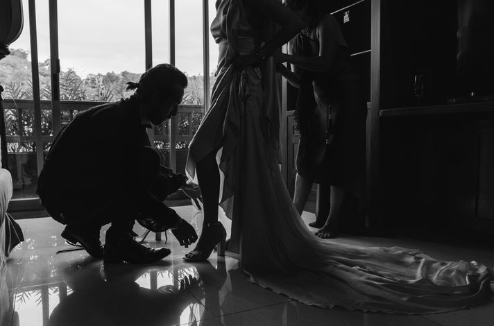 designer adjusting bride's shoes