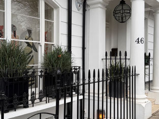 White stucco London townhouse with black iron railings and classical columns in Mayfair