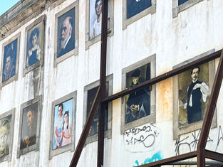 Portrait-style artworks inside window-like recesses in Porto’s historic centre