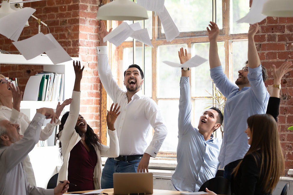 People in the office celebrating and throwing papers to the air
