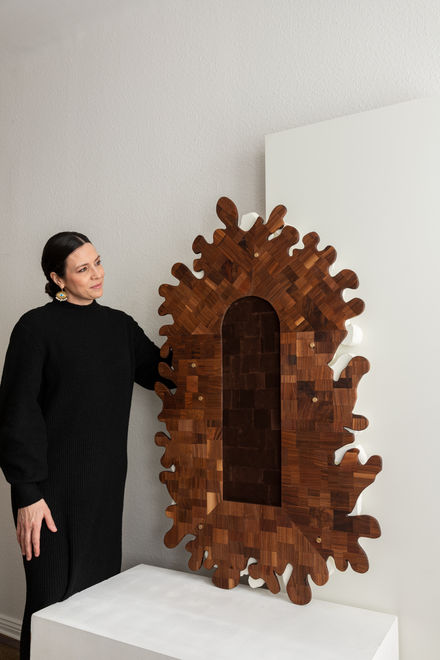 Koralli Bi-Layer Mirror backside, showcasing the puzzelwork walnut backing with designer Megan Bredlow