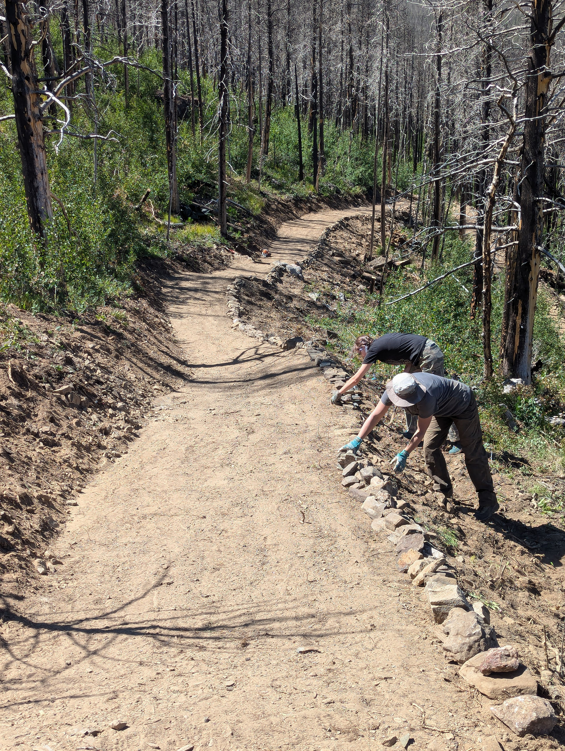 Putting the finishing touches on the new section of trail! Photo by Kara Garcia