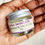 Thumbnail: mini rejuvenate face cream held in palm of hand