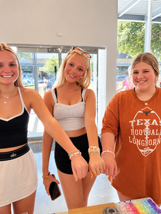 Women smiling with finished beaded jewelry