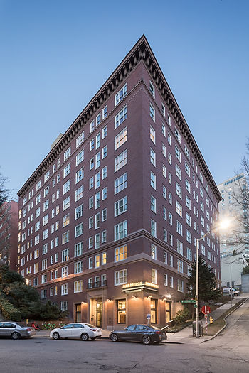 The front exterior of the Cambridge, a historic brick building, at twilight.
