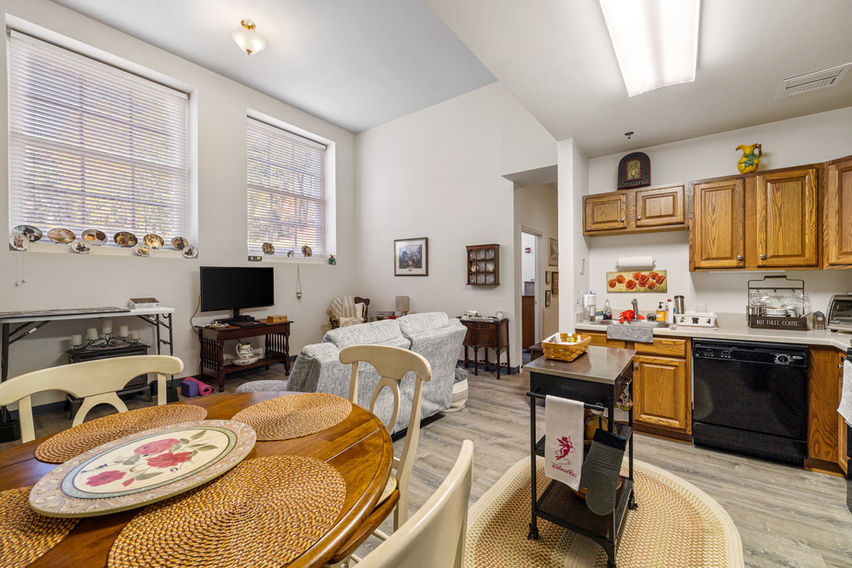 Photo of an apartment living space showcasing an open floor plan kitchen, living and dining room space. 