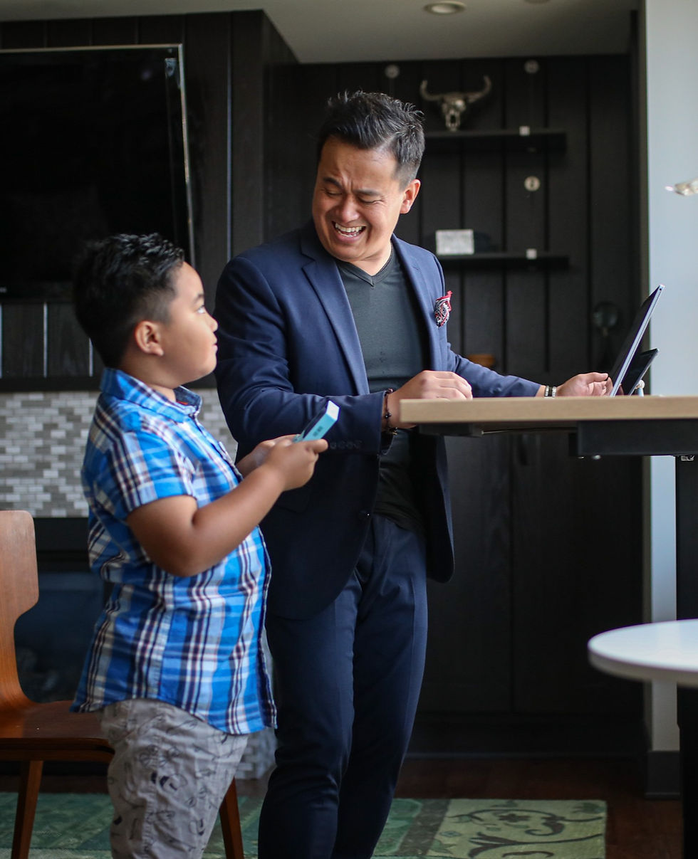 A father is smiling and laughing toward his son