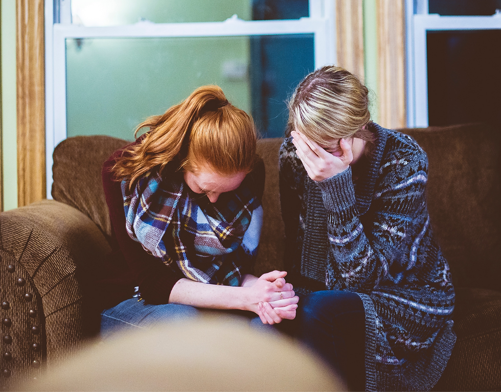 two women holding hands and crying