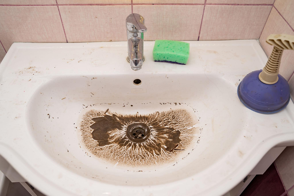 Clogged bathroom sink drain with heavy buildup and standing residue indicating drainage issues