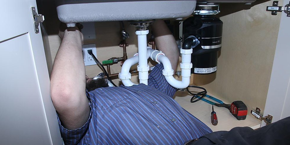 Plumber performing emergency drain cleaning using professional equipment
