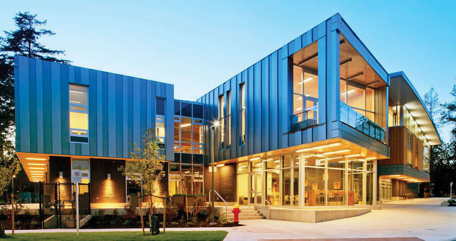Exterior photograph at dusk of the community centre at Silverdale in Mission, BC, featuring contemporary architectural design with metal cladding and large glazing.