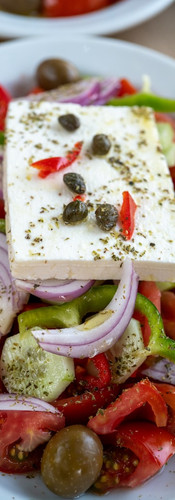 A plate of Greek Salad with tomato onion and feta cheese. 